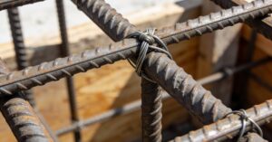 Łączenie zbrojenia wzdłuż prętów: jak dobrać długość zakładu w belce?